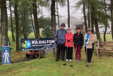 Four players standing on the first tee